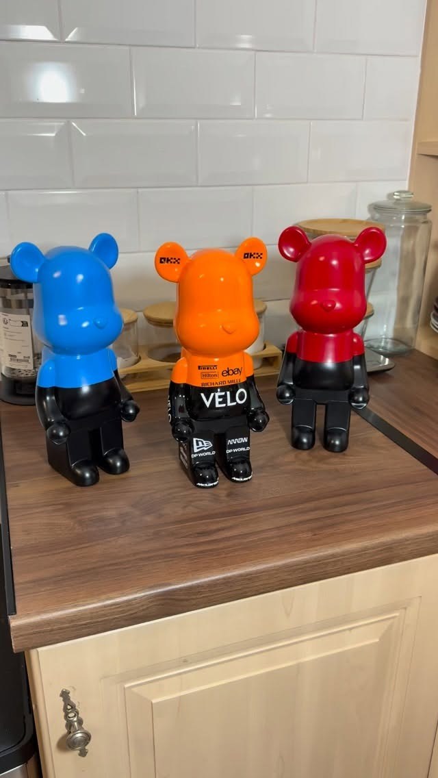 Three 3D-printed bear figures in blue, orange and red racing liveries.